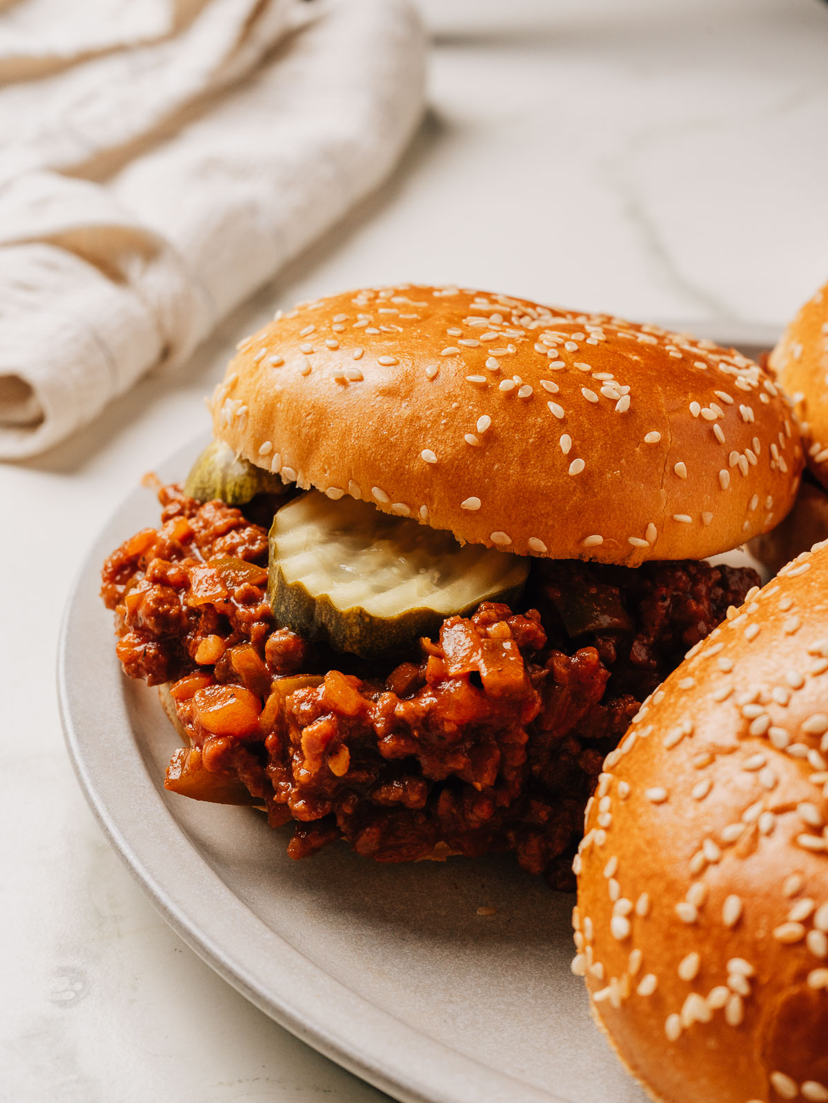 Easy sloppy joes recipe in a bun on a plate.