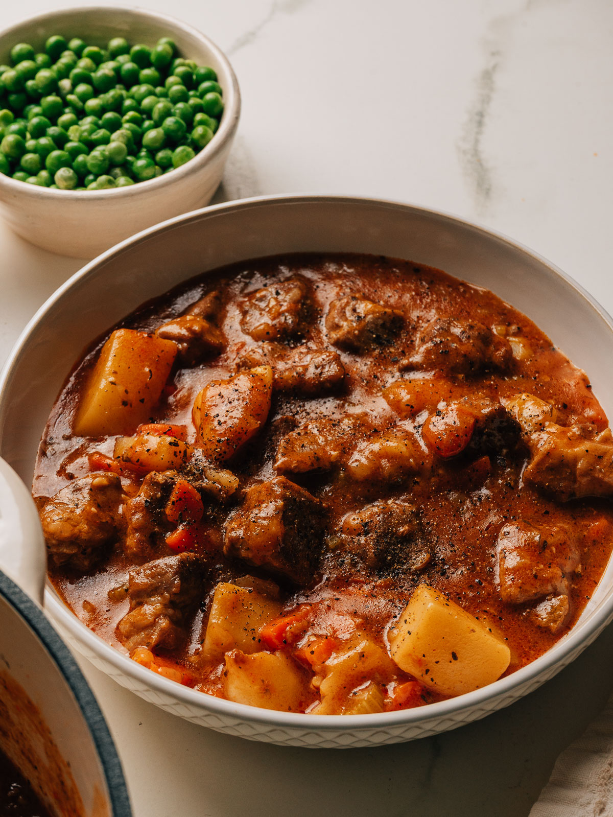 Pork stew with tender pork shoulder, potatoes, and carrots in rich gravy in a bowl.