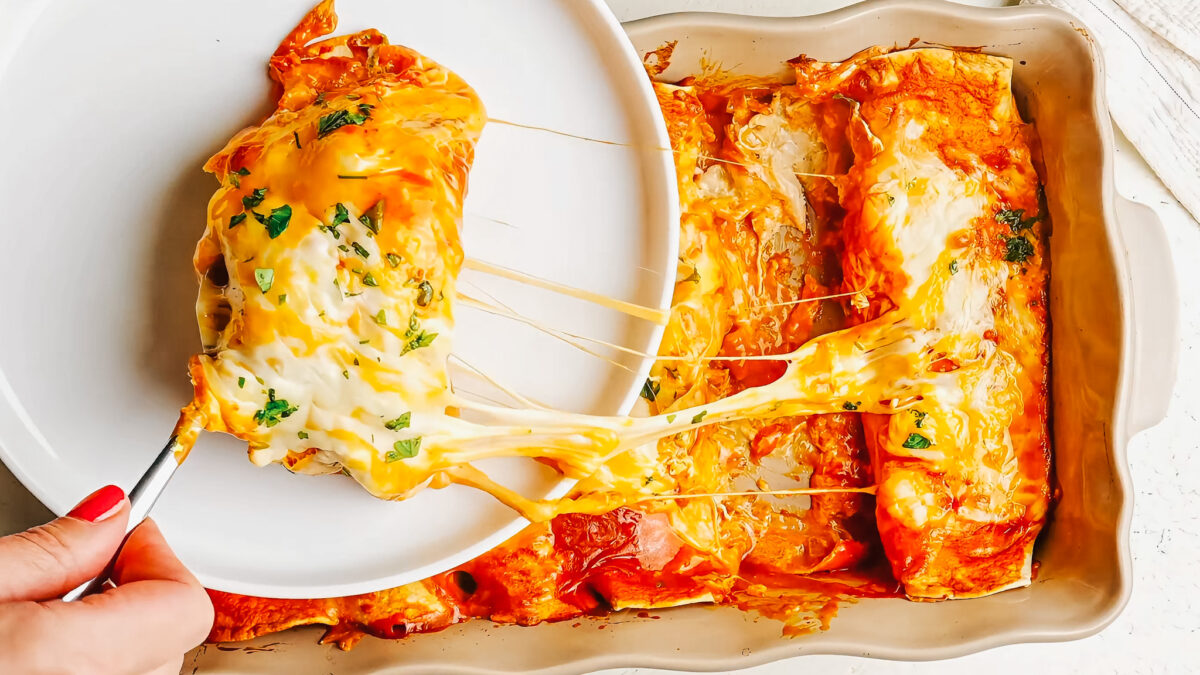 Pulling out a cream cheese chicken enchilada from the pan.
