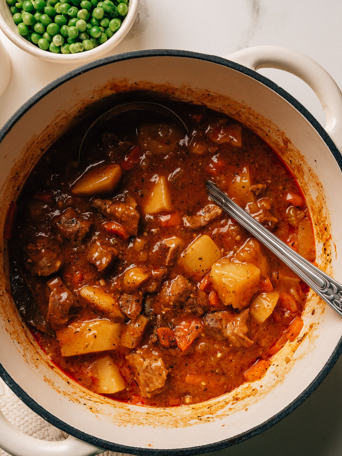 Pork stew in a dutch oven with a spoon.