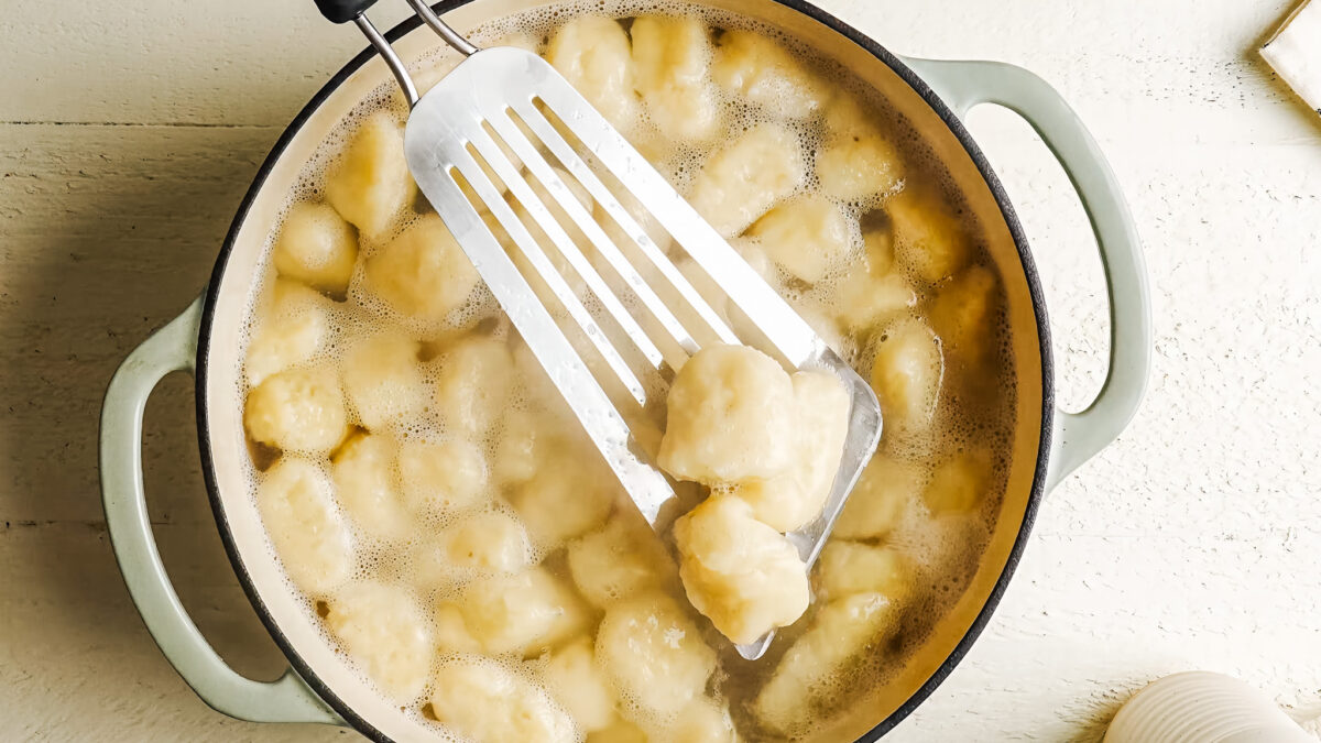 Cooked potato gnocchi floating in a pot of boiling water
