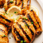 Grilled chicken thighs with balsamic chicken marinade on a plate.