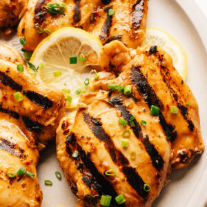 Grilled chicken thighs with balsamic chicken marinade on a plate.