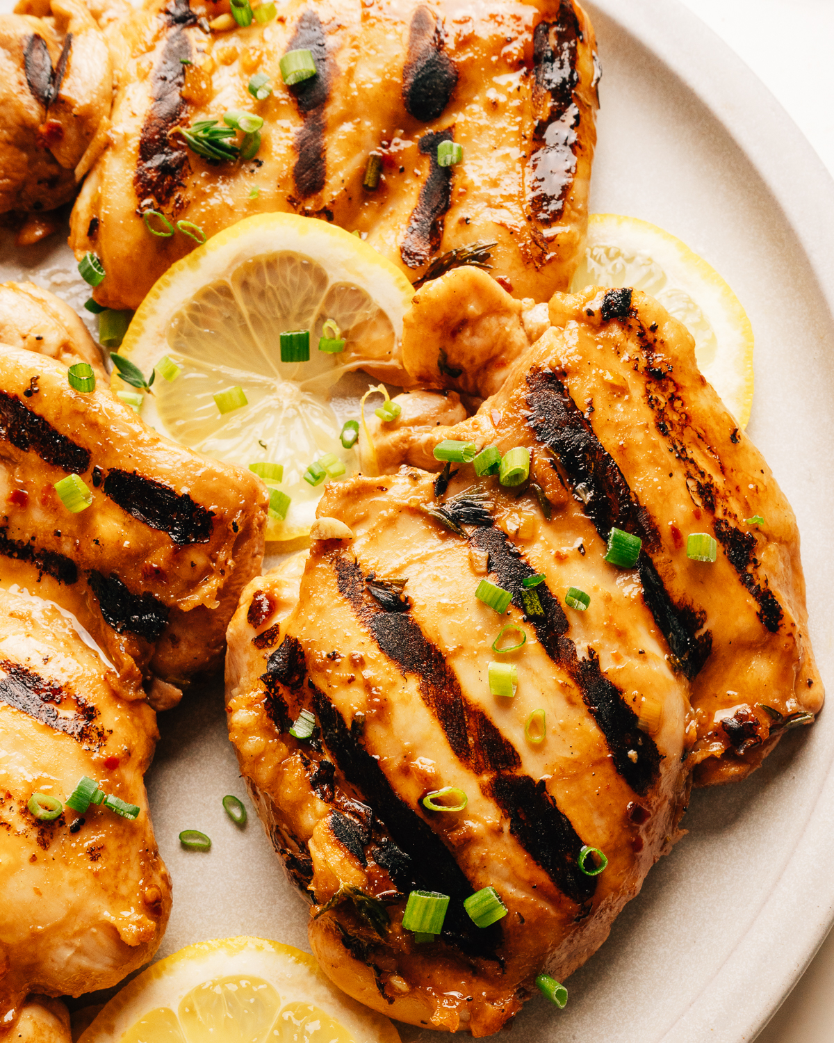Grilled chicken thighs with balsamic chicken marinade on a plate.