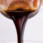 Homemade balsamic vinaigrette dressing being poured out.