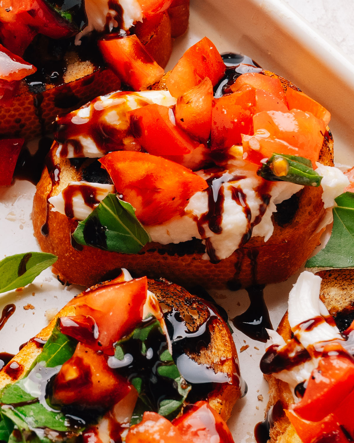Overhead tray of bruschetta with mozzarella, tomato and basil.