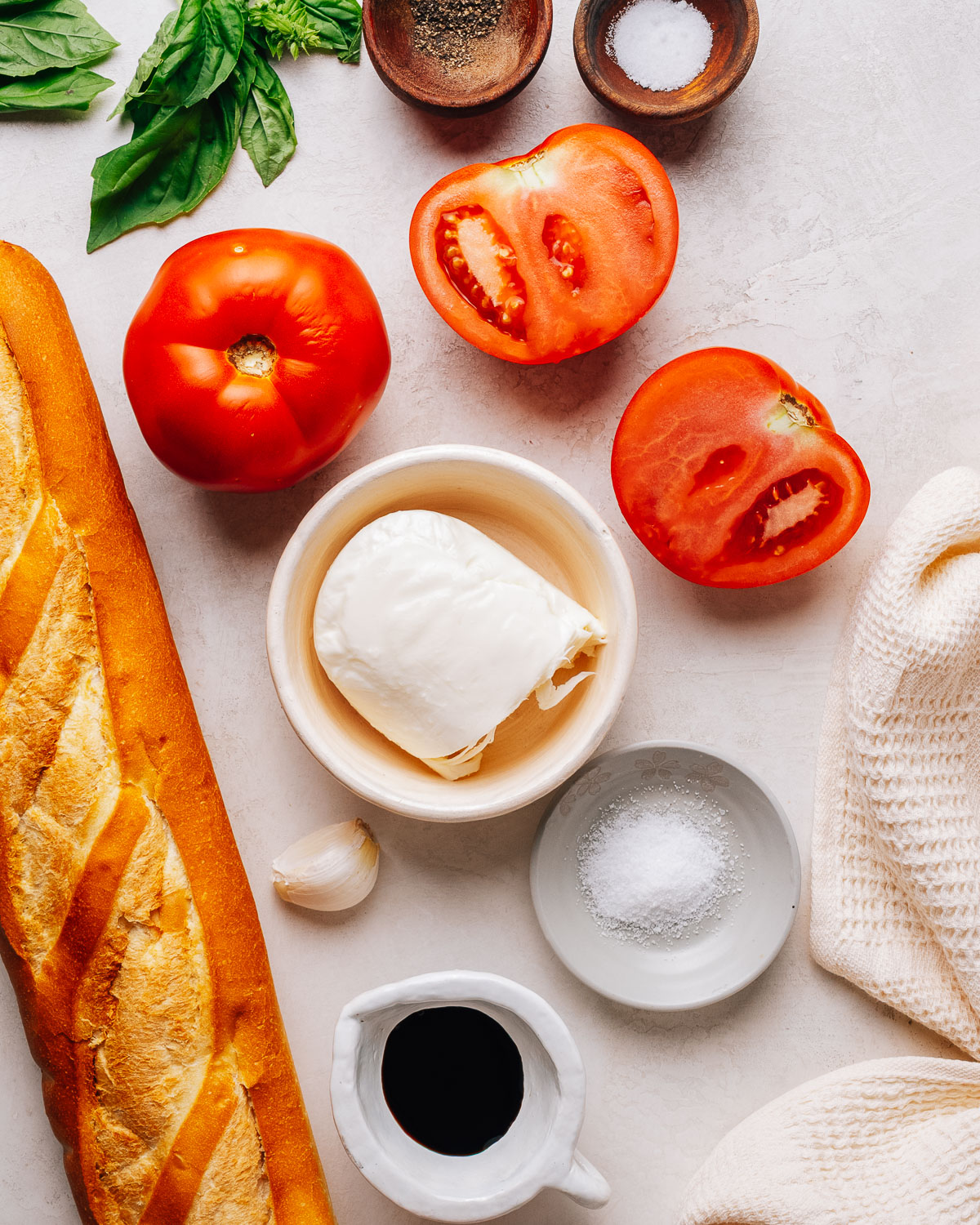 Ingredients for making bruschetta with mozzarella, tomato and basil.