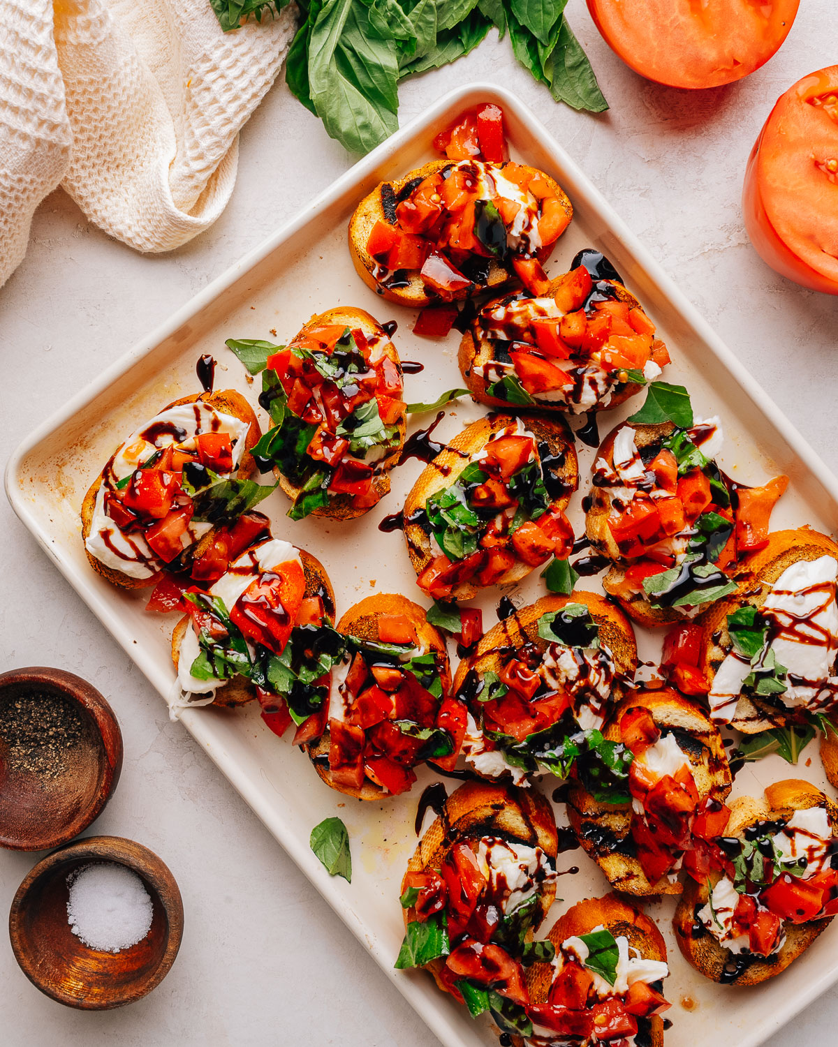 Overhead tray of bruschetta with mozzarella, tomato and basil.