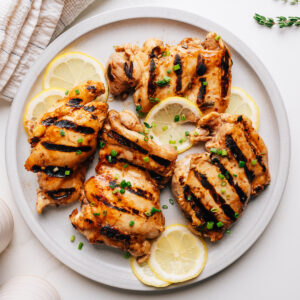 Grilled chicken thighs with balsamic chicken marinade on a plate.