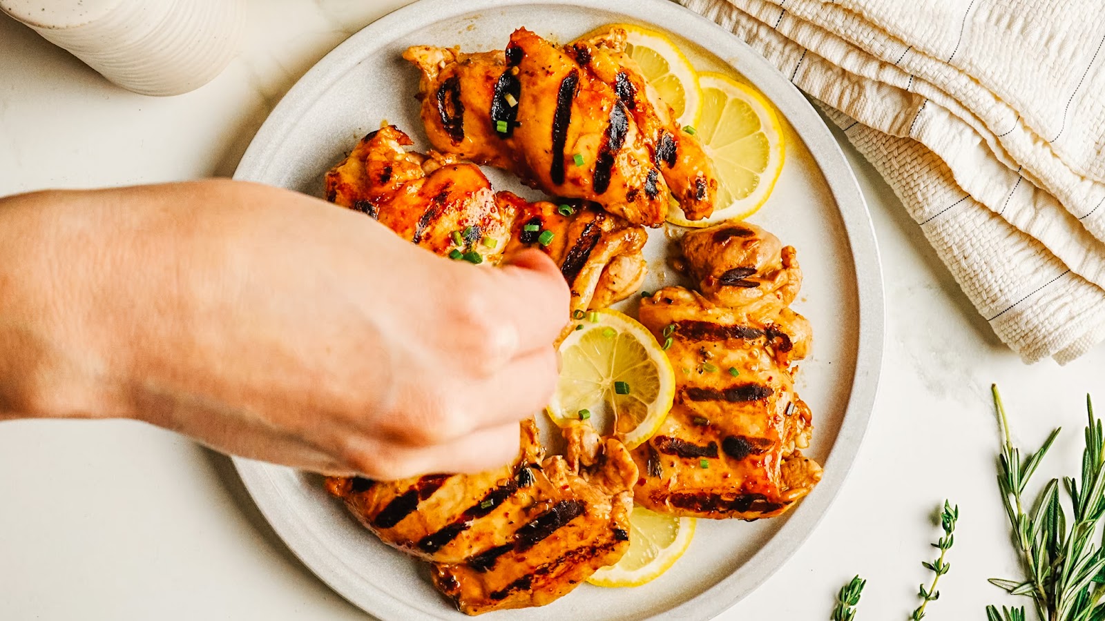 Squeezing fresh lemon over grilled balsamic chicken.