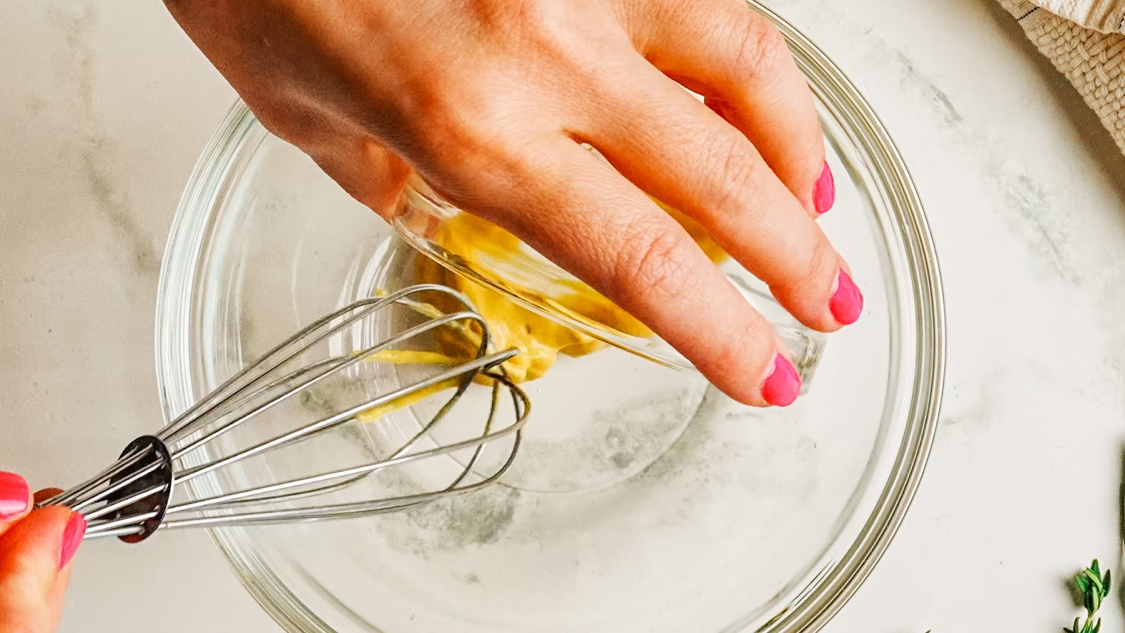 Whisking Dijon mustard in a glass bowl to start the marinade.