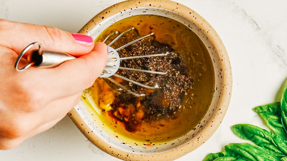 Whisking the balsamic dressing for caprese pasta salad.