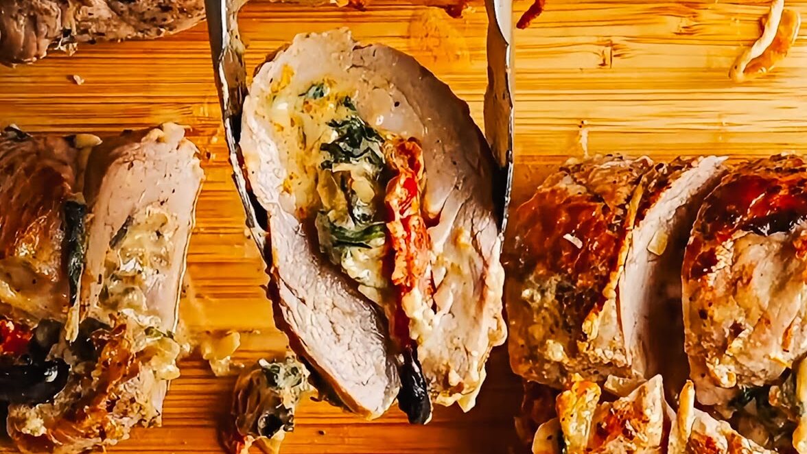 Slicing a stuffed pork tenderloin into rounds after roasting.
