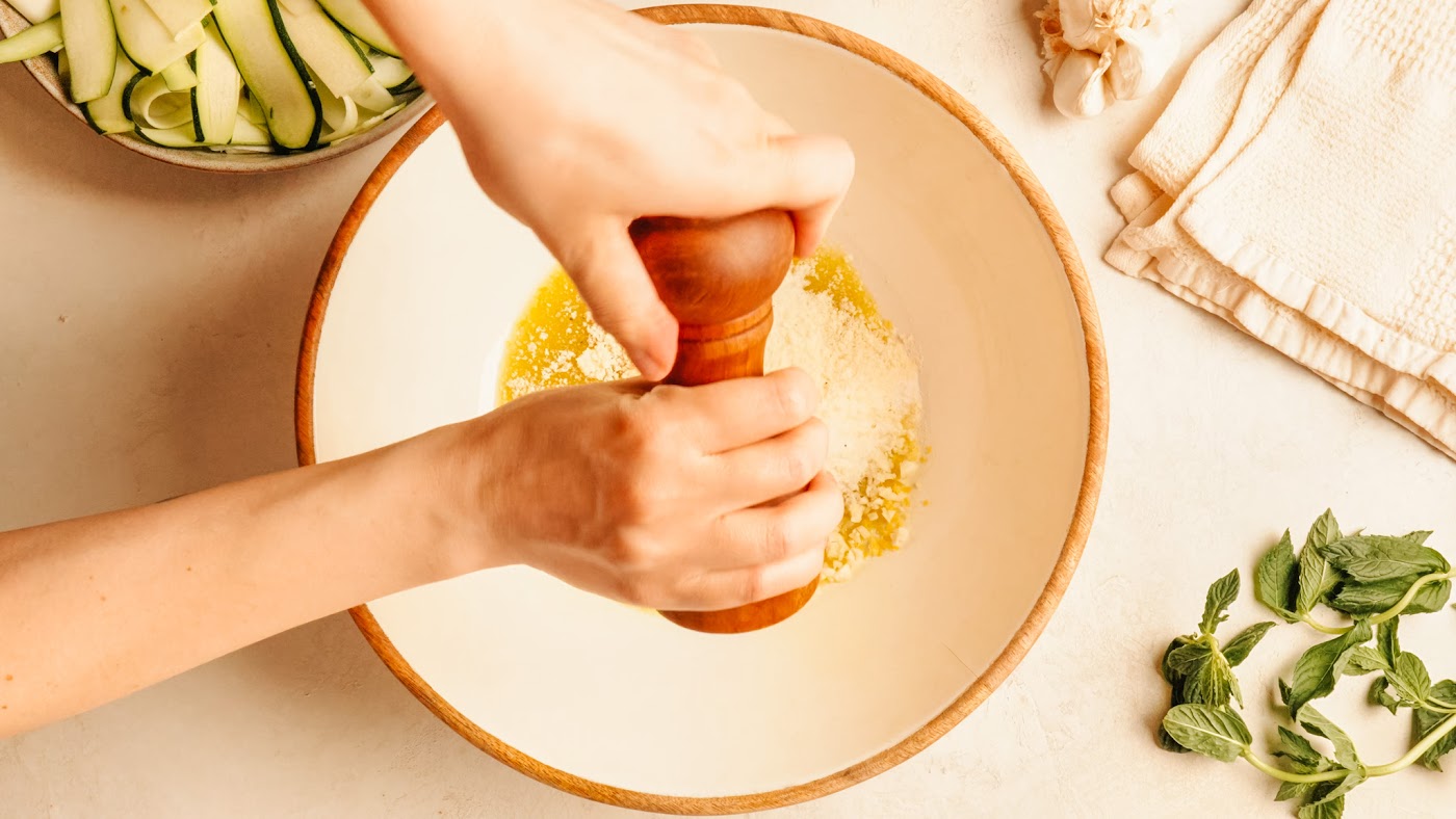 Whisking lemon and olive oil dressing in a bowl.