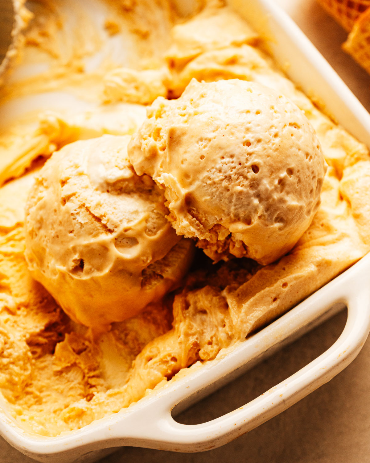 Scoops of homemade peanut butter ice cream in a dish.