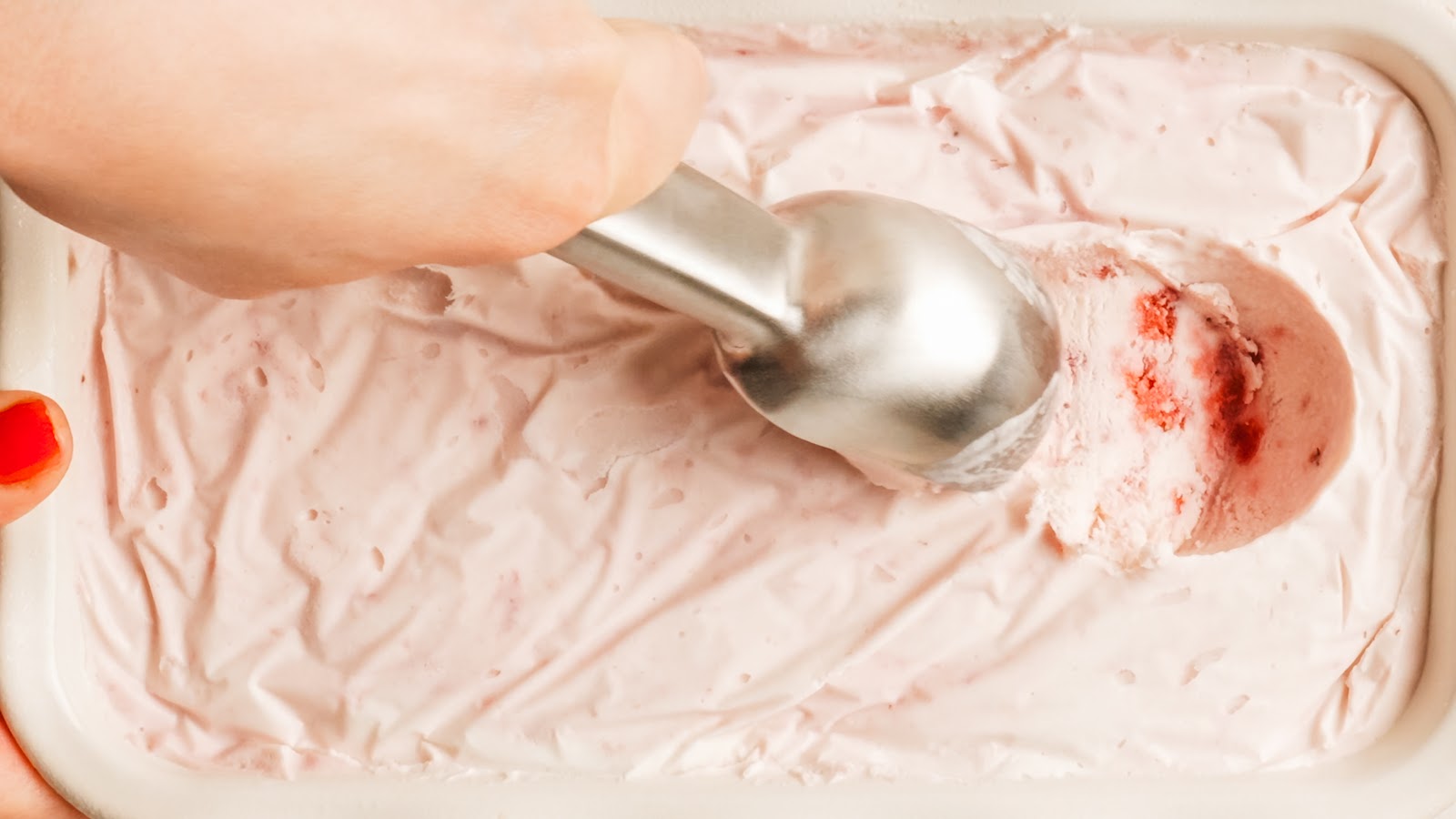 Close-up of a scoop of creamy homemade strawberry ice cream.