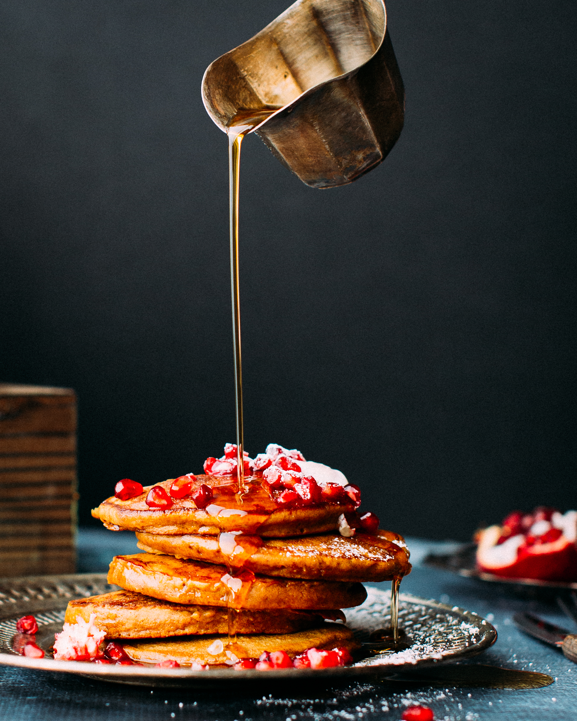 Drizzling a stack of christmas pancakes with maple syrup.