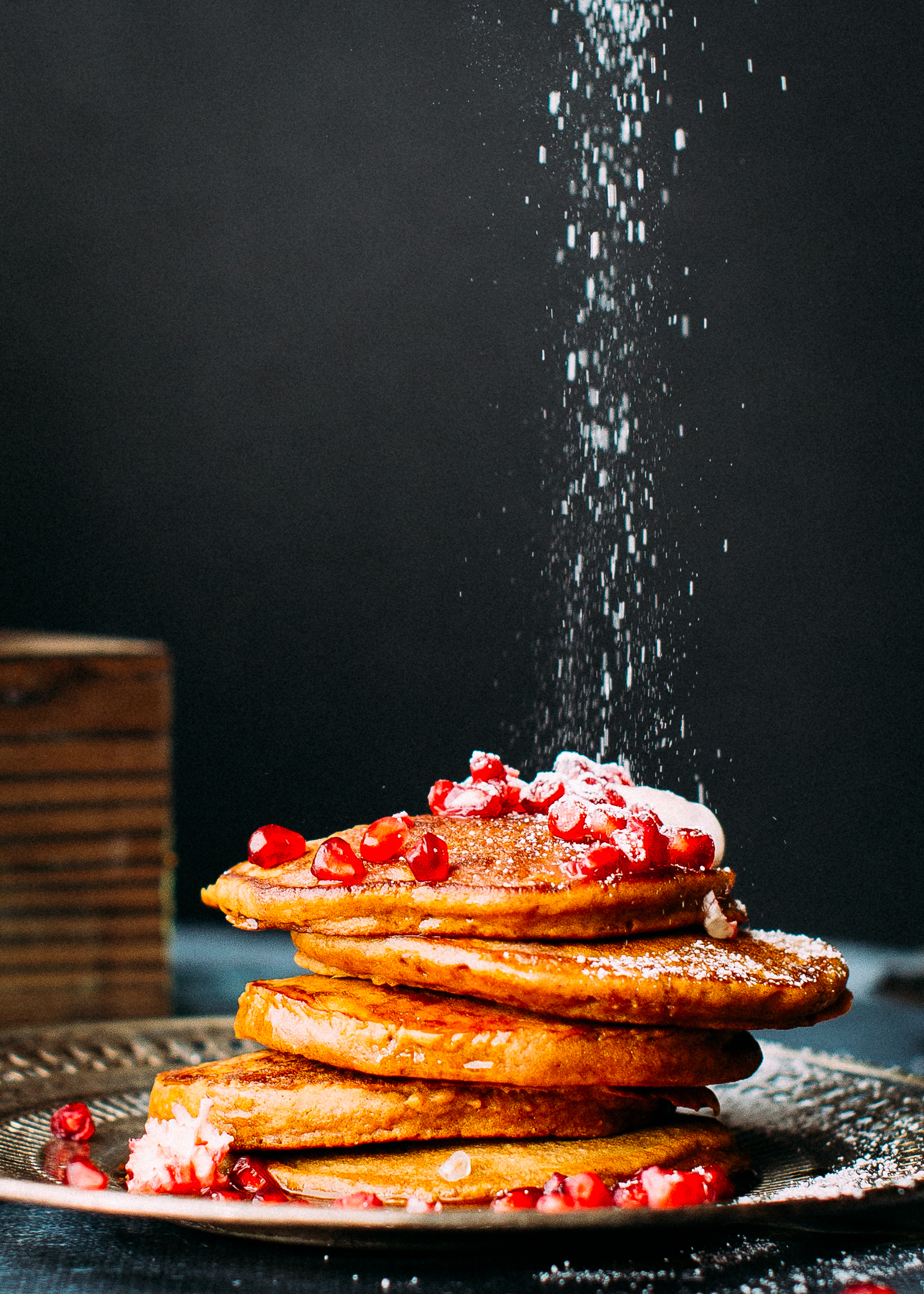 Dusting a stack of christmas pancakes with icing sugar.